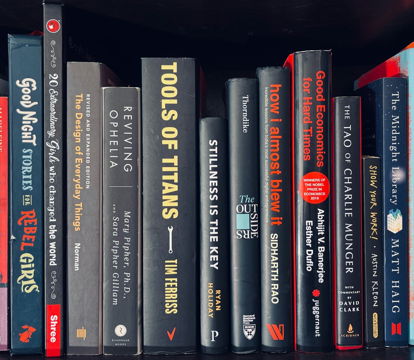 a row of books sitting on top of a book shelf